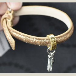 Nyt armbnd med afdmpet guldglitter og charm. 5 indstillingshuller. Nypris 299kr.