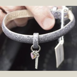 Nyt armbnd med mrkt slvglitter og charm. 5 indstillingshuller. Nypris 299kr.