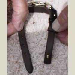 Armbnd i mrkbrunt lder og guldkde holdt fast med sorte lderbnd. Returvare uden brugsspor.