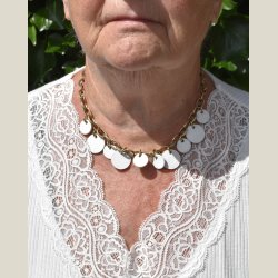 Halskde med guldbelgning og hvide ldercirkler. Let slitage.