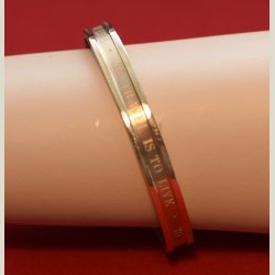 Metalarmbnd i bronce med slogan "to travel is to live". Sm brugsspor. Diameter 6,5cm.