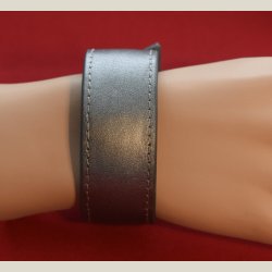 Spndende lderarmbnd i grt. Brugt uden det kan ses. Omkreds 18cm.