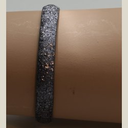 Nyt armbnd med mrkt slvglitter og charm. 5 indstillingshuller. Nypris 299kr.