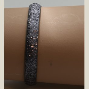 Nyt armbnd med mrkt slvglitter og charm. 5 indstillingshuller. Nypris 299kr.