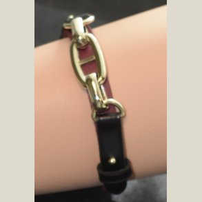 Armbnd i rdlilla lder og guldkde holdt fast med sorte lderbnd. Ny. Nypris 549kr.