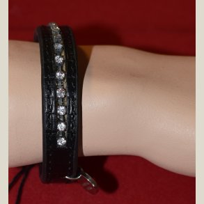 Sort lderarmbnd med klare sten og D/K charm. Returvare uden fejl.