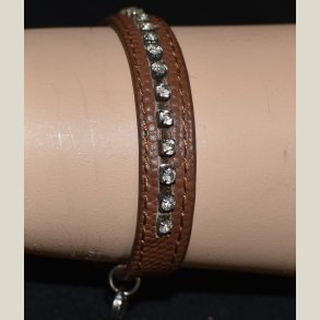 Lderarmbnd med klare sten og D/K charm. 2 indslillingshuller. Let brugt.